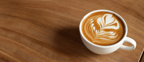 a cup of latte art coffee on wooden background                              