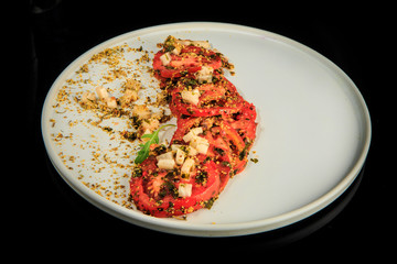 top view on sliced tomato exclusive decorated with assorted herbs