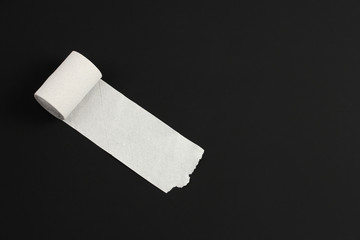 unrolled white toilet paper on black background, close-up, copy space, concept of notebook for...