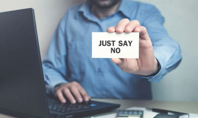 Businessman holding Just Say No text on business card.