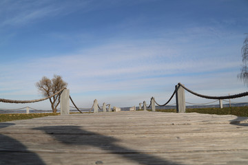 Mole (pier) on the lake. Wooden bridge with blue lake.