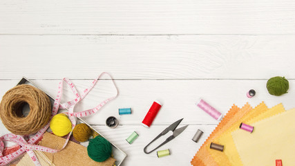 Sewing background. Accessories for needlework on old wooden background.