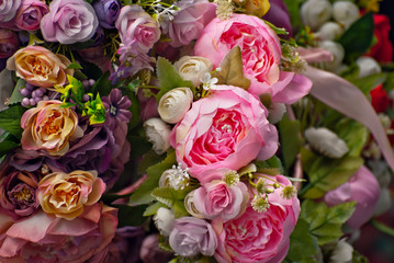 Bouquets of artificial flowers are sold at the fair. Corollas of colored small flowers. Closeup of national decorations and accessories for clothing.