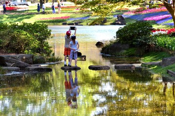 Fototapeta na wymiar 公園の池で遊ぶ外国人の子供