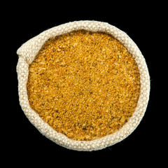 A mixture of seasonings in a bag isolated on a black background. Spice on isolate. View from above. Dry seasoning.
