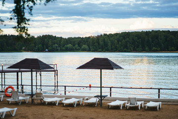 Warm summer evening in city park on the nature shore pond.