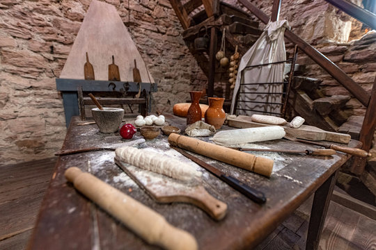 Medioevo: cucina con tavola di preprarazione cibi e pietanze in ambiente muri in pietra e sasso