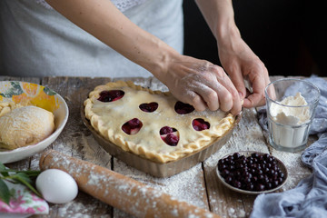 Obraz na płótnie Canvas Cooking cherry pie. Work with the test.Bake a fruit cake in the shape of a heart. Delicious homemade cake do it yourself. Cooking. Valentine's Day. Heart shape. Ready for Valentine's Day.