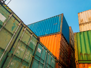 Between The Logistic Container Stack High Against The Blue Sky After Loading. Concept of Cargo or Material Goods Shipment and Transport in Port
