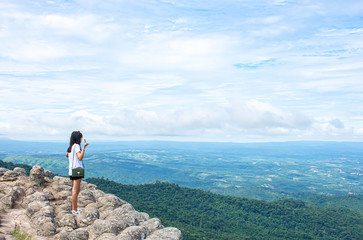 Asian woman raise their arms on the point of view of the mountains at Patio stone button in Phu Hin...