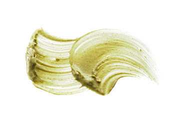 Texture and strokes of a light green organic mask for face or body cream isolated on white background