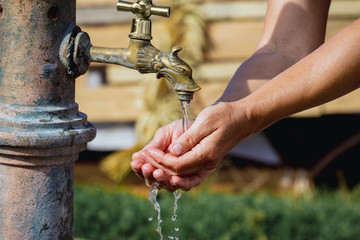 Woman washes her hands under the tap on the street_