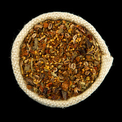 Mix of spices in a bag isolated on black background. View from above. Seasoning on isolate. Dry spices.