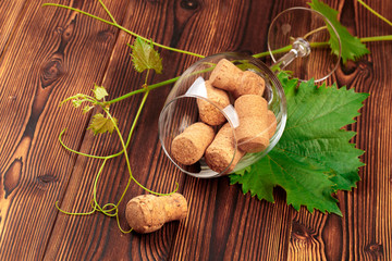 glass of wine with cork on wooden background.