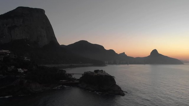 Aerial view of Joatinga beach with the Gavea, Vidigal and Corcovado mountains of Rio de Janeiro in the background and Costa Brava club on an island in the foreground at golden hour