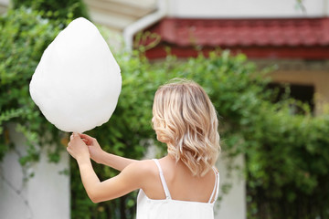 Woman with sweet cotton candy outdoors