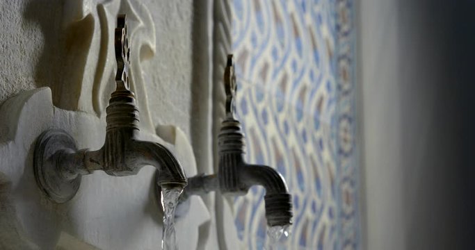 Close-up slow motion of water flows of the old taps in the Turkish bath Hammam