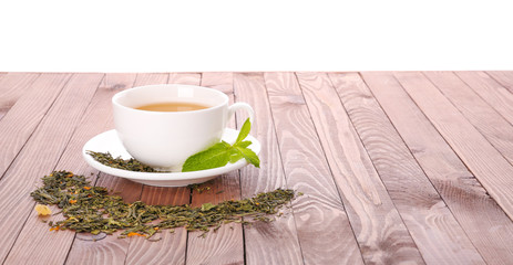 Cup of tasty tea with mint on wooden table against white background