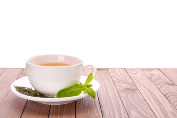 Cup of tasty tea with mint on wooden table against white background