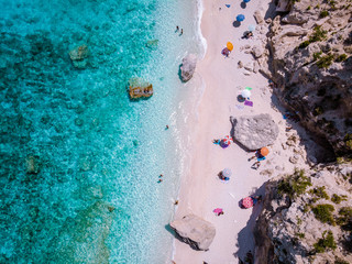 View from above, stunning aerial view of a beautiful beach full of beach umbrellas and people...