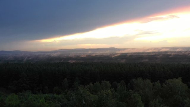 Over the Siberian taiga hung a bright sunset closed powerful cloud and fog removed from the quadcopter