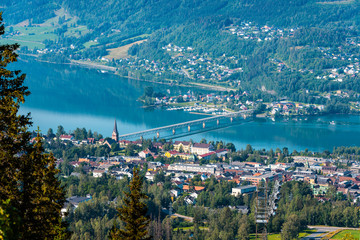 View of Lillehammer town with mountains, river and buildings.