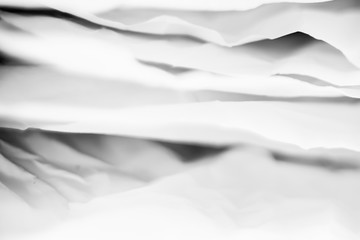 White crumpled paper layers with black shades. Creative design. Abstract background. Copy space.