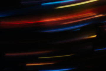 Blur night city lights in motion. Defocused multicolor glowing lines. Dark abstract background.