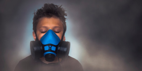 Young boy wearing gasmask, respirator portrait. Effects of worldwide air pollution, industrial...