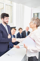 Obraz premium Geschäftsfrau schüttelt Hände mit einem Bewerber