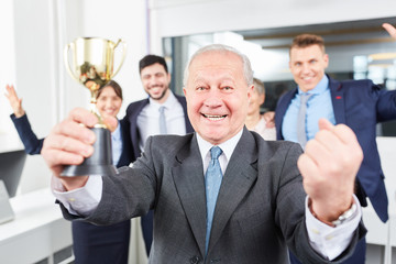 Erfolgreicher Unternehmer mit Pokal jubelt