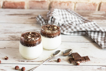 Dessert, milk chocolate jelly with chopped chocolate and nuts. Transparent glasses with chocolate...