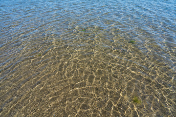 Smooth water surface with sand bottom