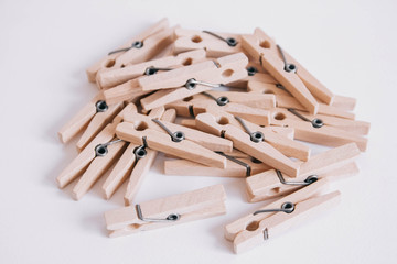Wooden clothespins scattered on a white background. View from above. Copy space