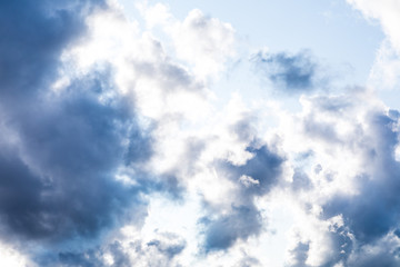 The vivid sky or heaven background with white and blue clouds under the sun rays