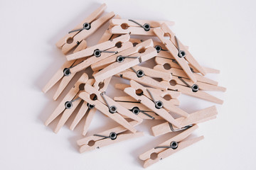 Wooden clothespins scattered on a white background. View from above. Copy space