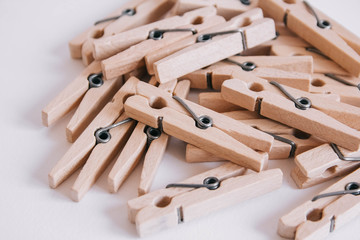 Wooden clothespins scattered on a white background. View from above. Copy space