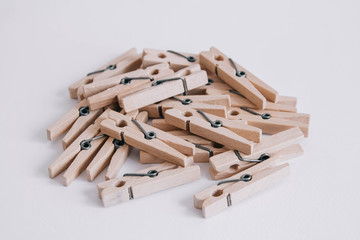 Wooden clothespins scattered on a white background. Copy space