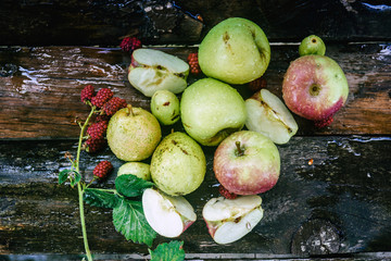 Fototapeta na wymiar Explosion of different berries. Photo of apples, plums, blackberry, on wooden table. Top view. High resolution product.