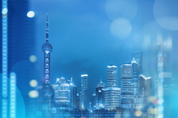 Shanghai business landmark at night view with abstract bokeh at foreground in blue tone.