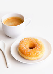 Cup of coffee with classic sugar donut on white background.Copy space