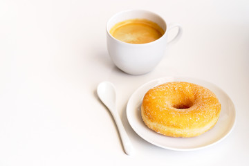 Cup of coffee with classic sugar donut on white background.Copy space