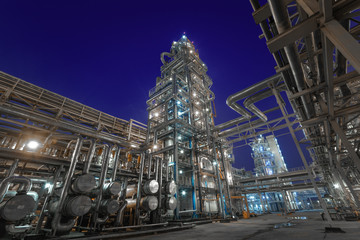 view of metal pipes of illuminated industrial plant outdoor at night 