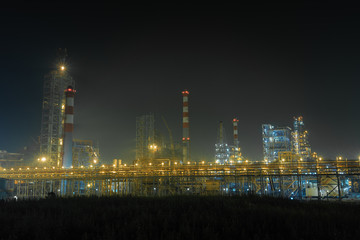 Fototapeta na wymiar the form of metal pipes of a refinery in the open air at night