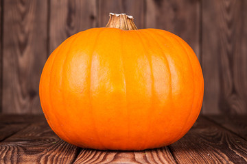 Ripe fresh pumpkin on a wooden background
