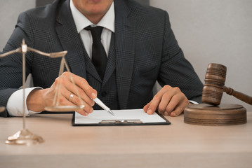 Law and Legal services concept. Male lawyer or judge working with contract papers, Law books and...