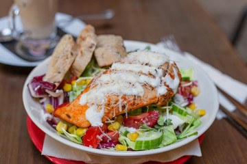 Dinner at restaurant. Close-up salad with grilled chicken, corn, tomato and cucumber