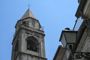 Bell tower from church of the Saints Gervasio and Portasio in Virgoletta, a beautiful ancient mountain village, district of Villafranca in Lunigiana, Tuscany, Italy, blue sky, selected focus