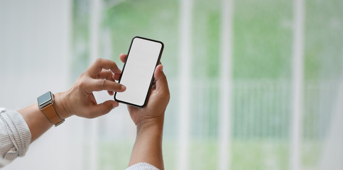 Close-up view of man holding blank screen smartphone