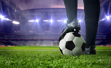 Soccer player foot close up in a stadium during football match under bright spotlights